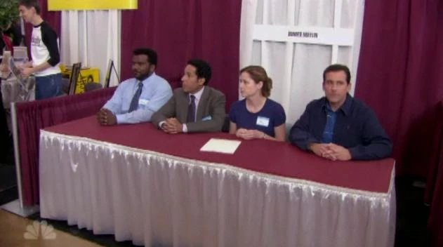 Michael, Pam, Oscar and Darryl at a school job fair in an episode of The Office