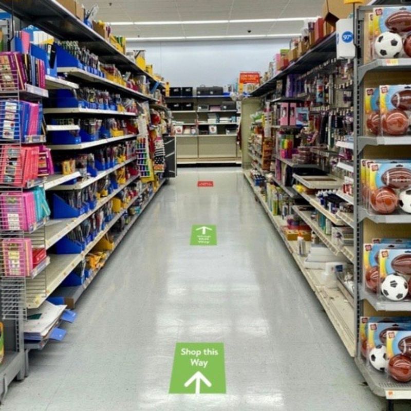 inside grocery store with stickers on the floor that direction flow of shopping customers