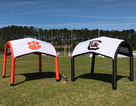 Two college branded Nitrox AIRFRAME inflatable tents at football field.