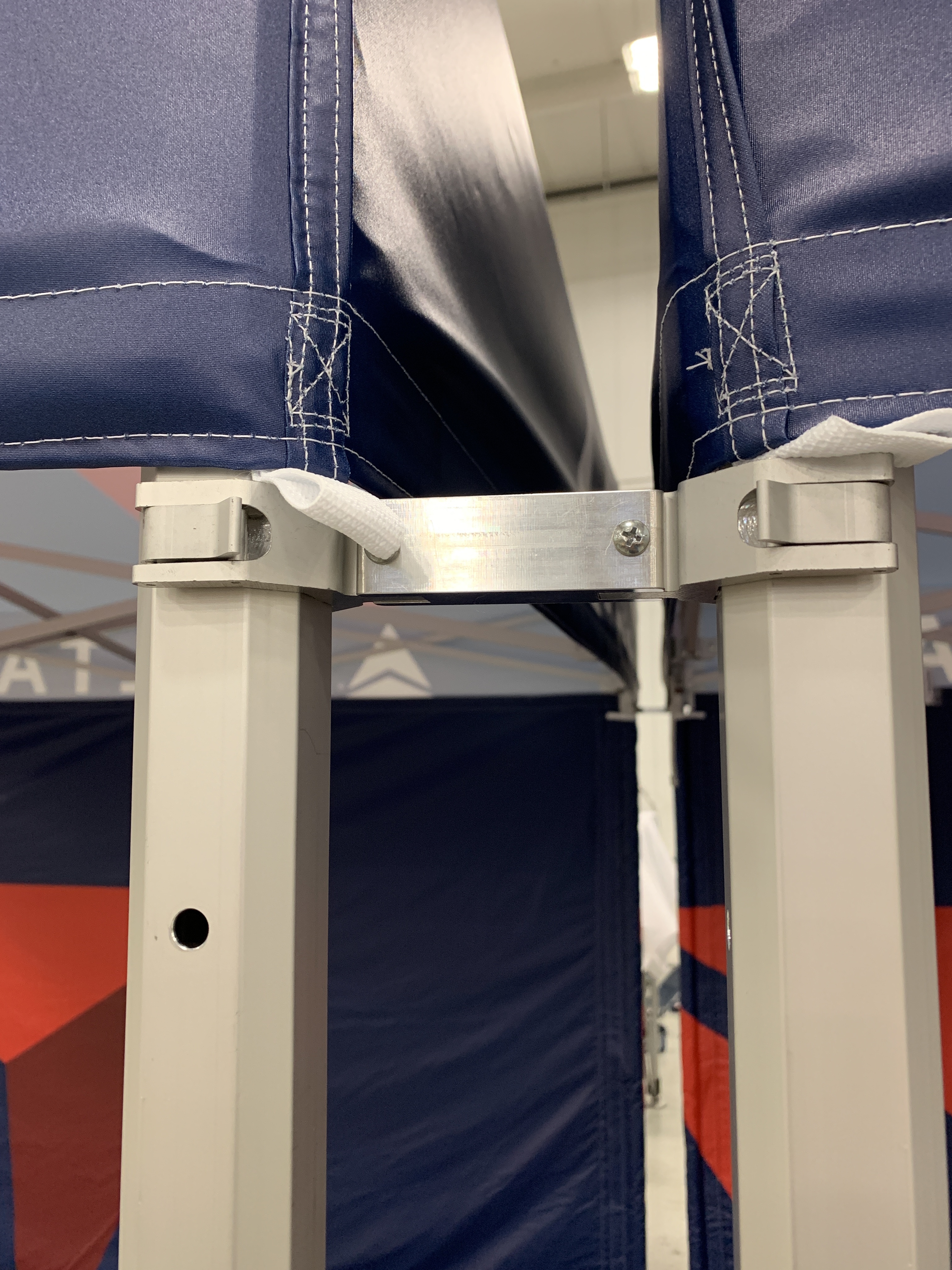 A connecting clamps connecting two different pop-up tents.